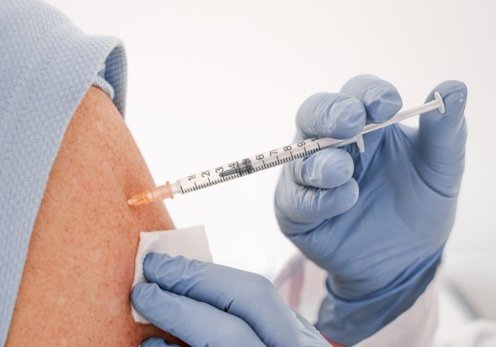 Booster covid-19 vaccine.Close up of a Doctor making a vaccine in the shoulder of patient